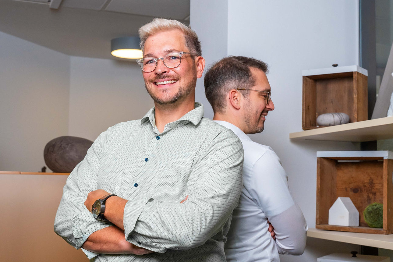 Zwei Männer stehen Rücken an Rücken in einem Büro