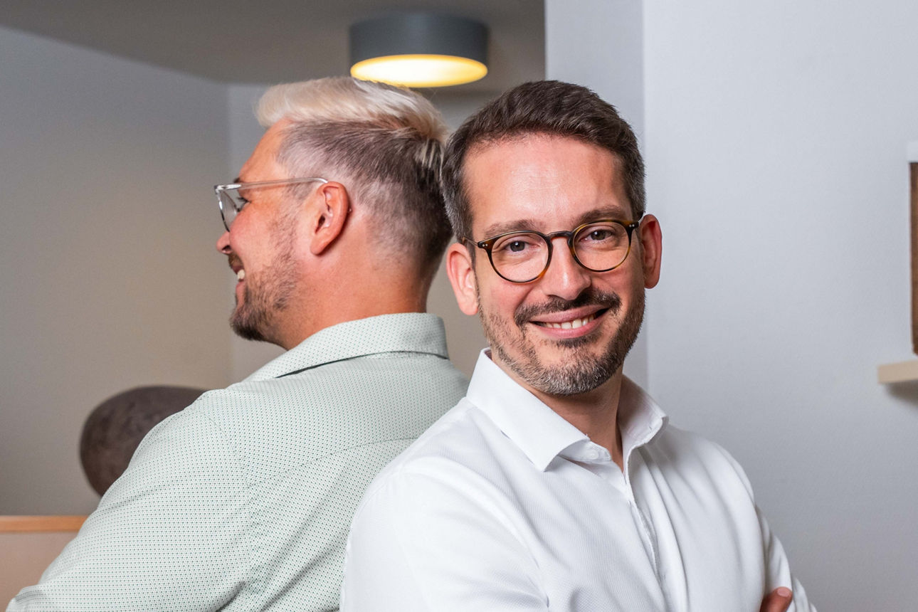 Zwei Männer stehen Rücken an Rücken in einem Büro