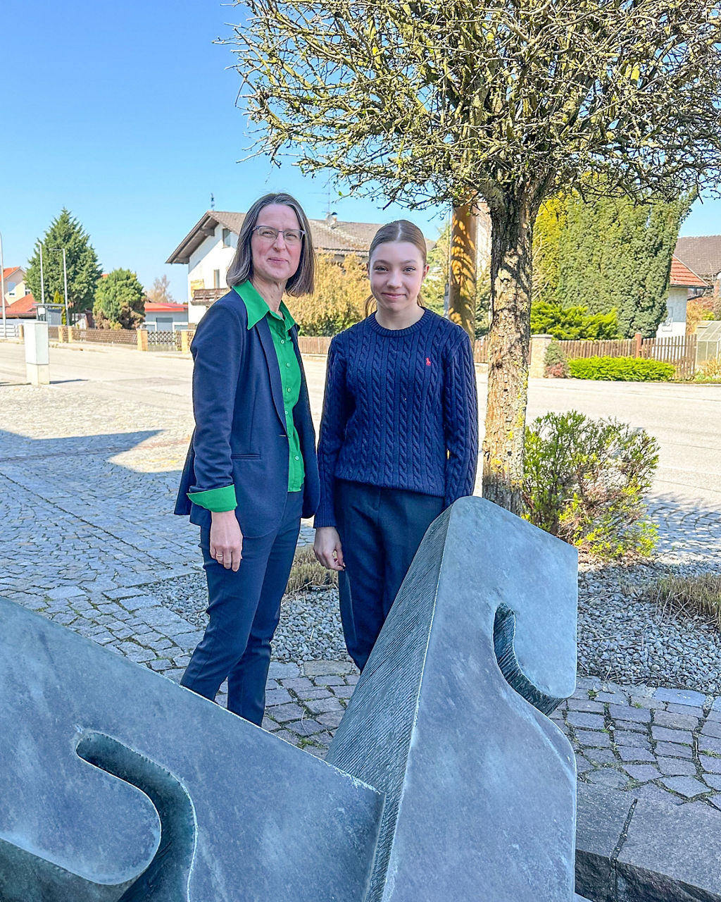 Zwei Frauen stehen auf einem Platz vor einer VR Skulptur