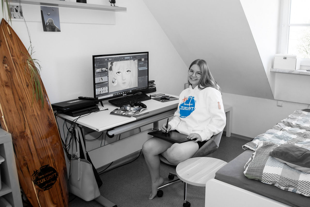 Mädchen sitzt an einem Schreibtisch vor dem PC