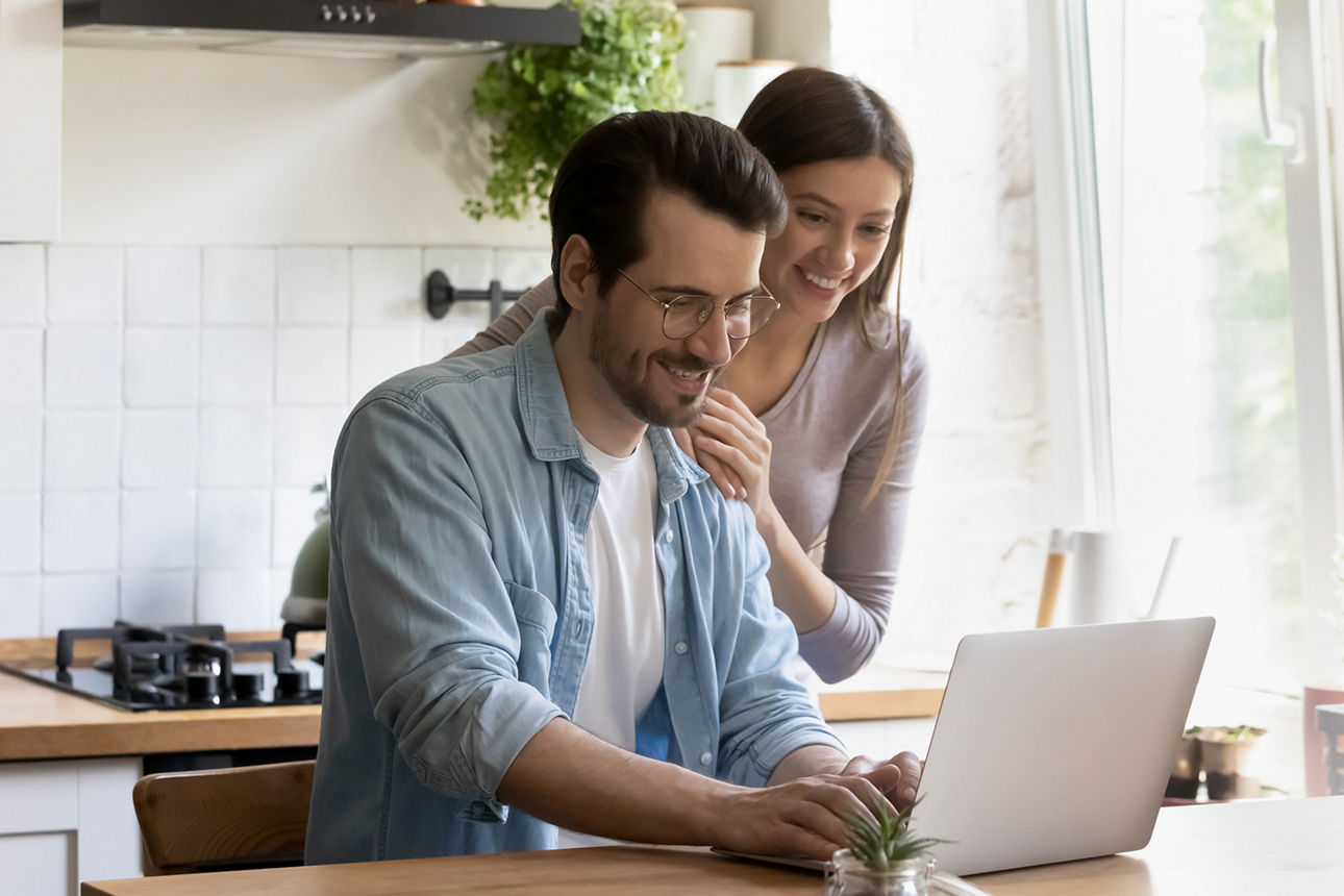 Mann und Frau mit Laptop in Küche