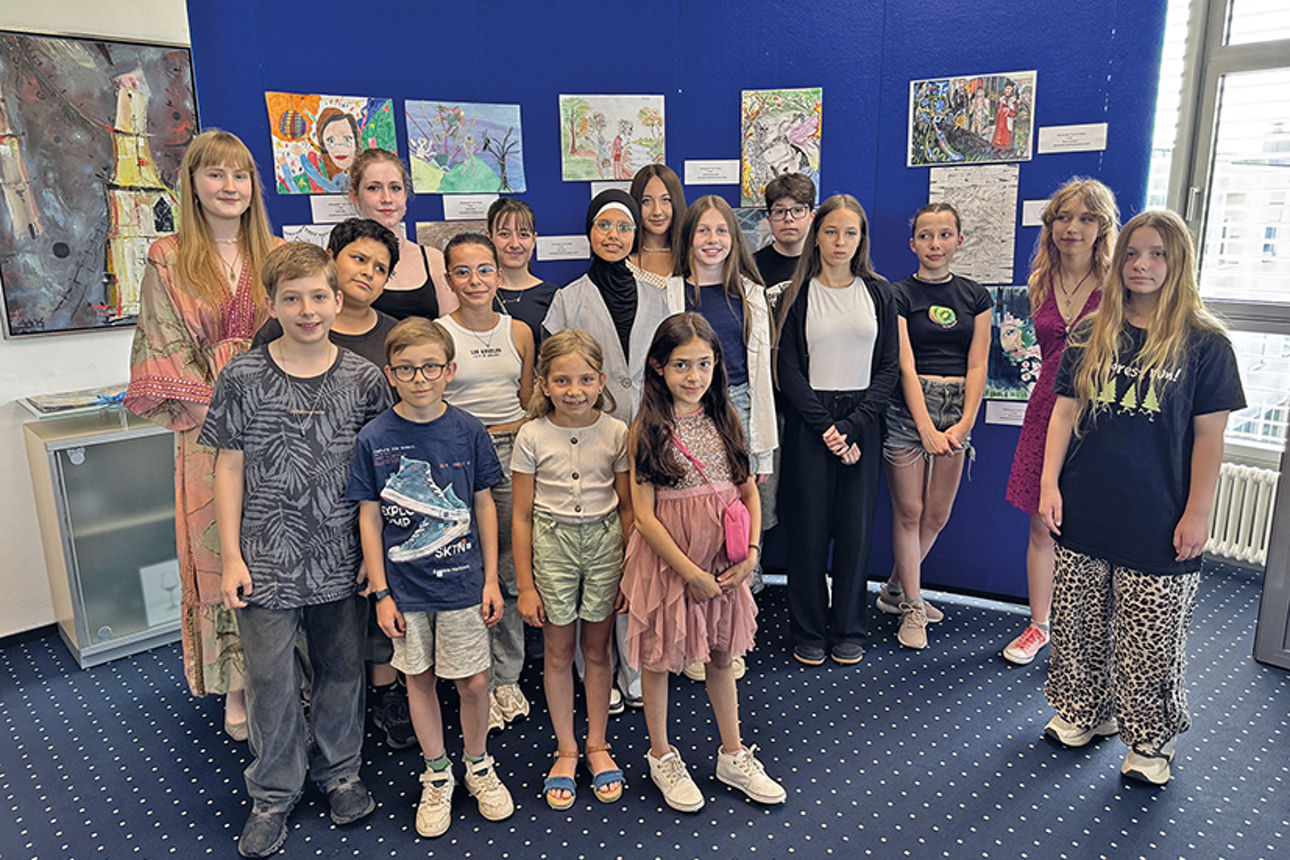 Gruppe Kinder steht vor einer Wand mit Bildern 