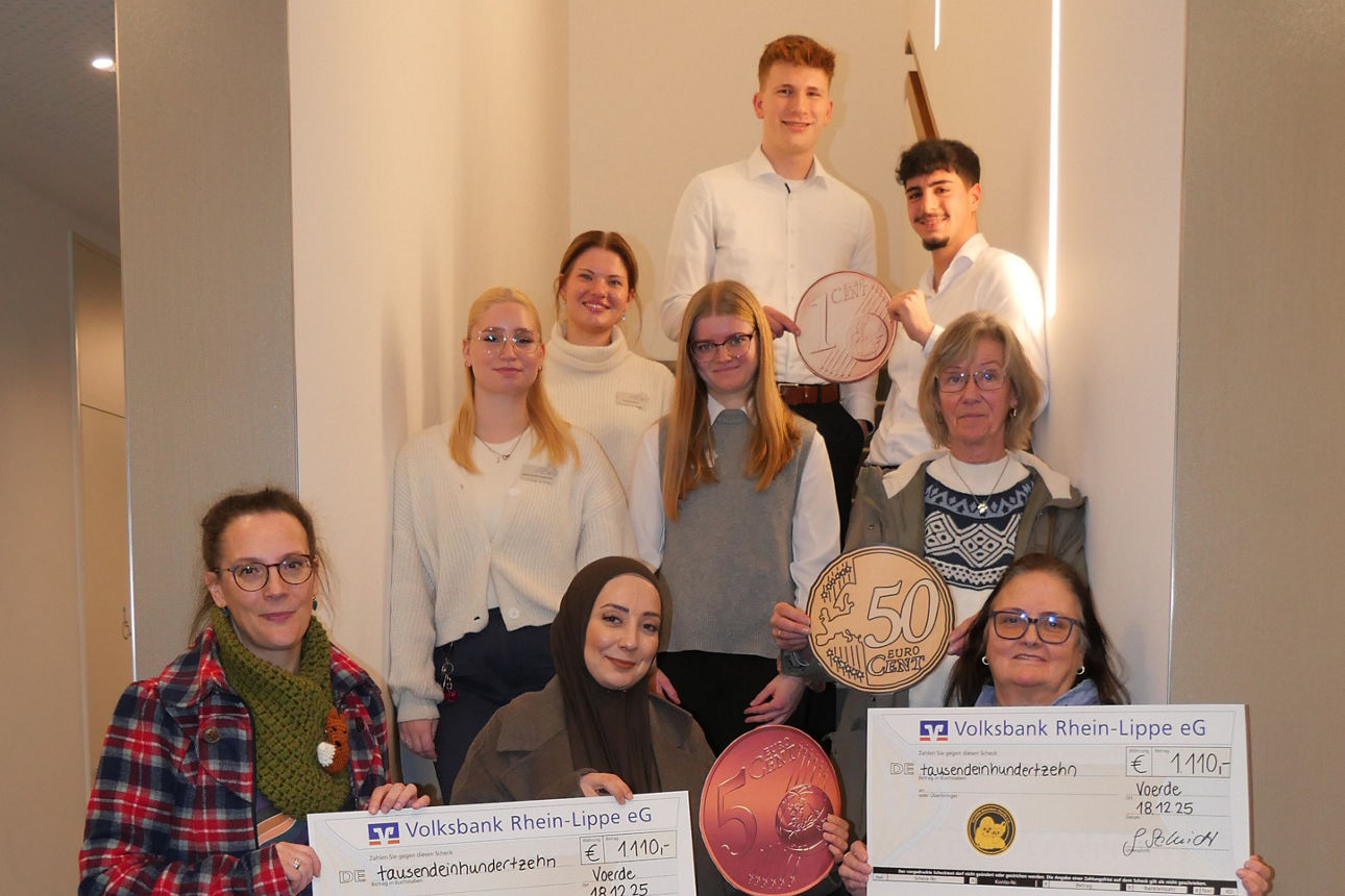 Menschen stehen in einem Gang und halten einen Spendenbeleg hoch