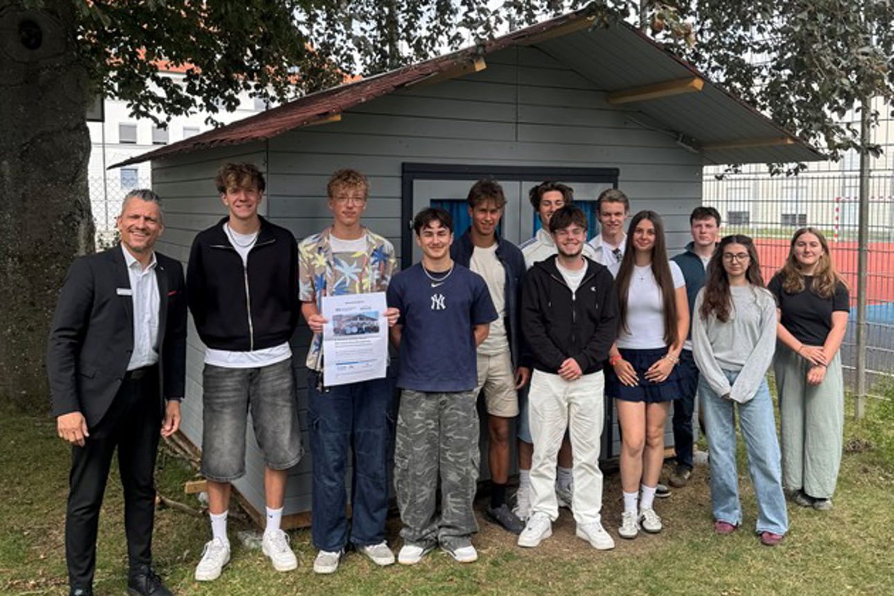 Gruppe an Personen stehen vor einer Gartenhütte