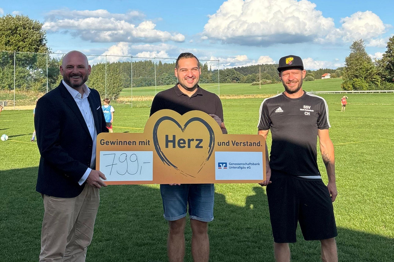 Drei Personen halten ein Schild 