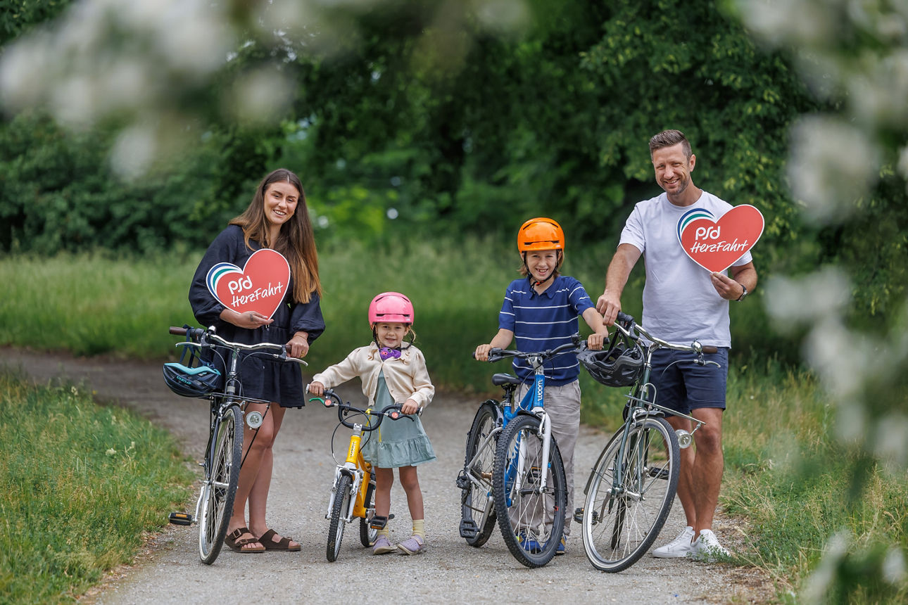 Eine Familie fährt mit ihren Kindern auf dem Fahrrad für den guten Zweck.
