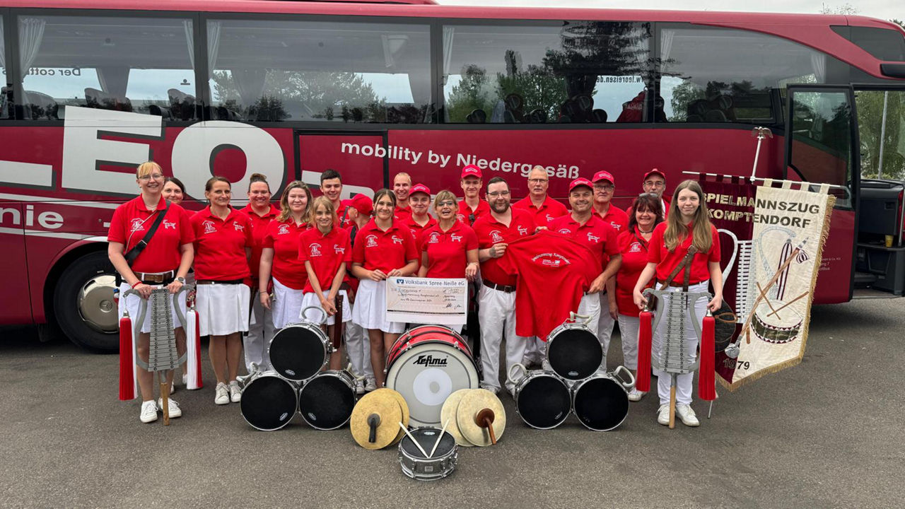 Mitglieder des Vereins mit Instrumenten vor einem Bus