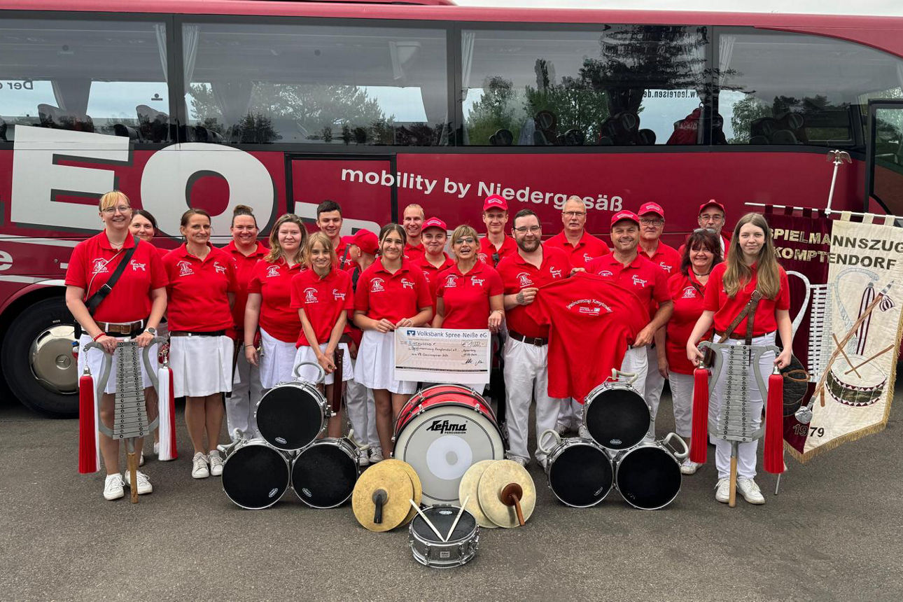 Mitglieder des Vereins mit Instrumenten vor einem Bus