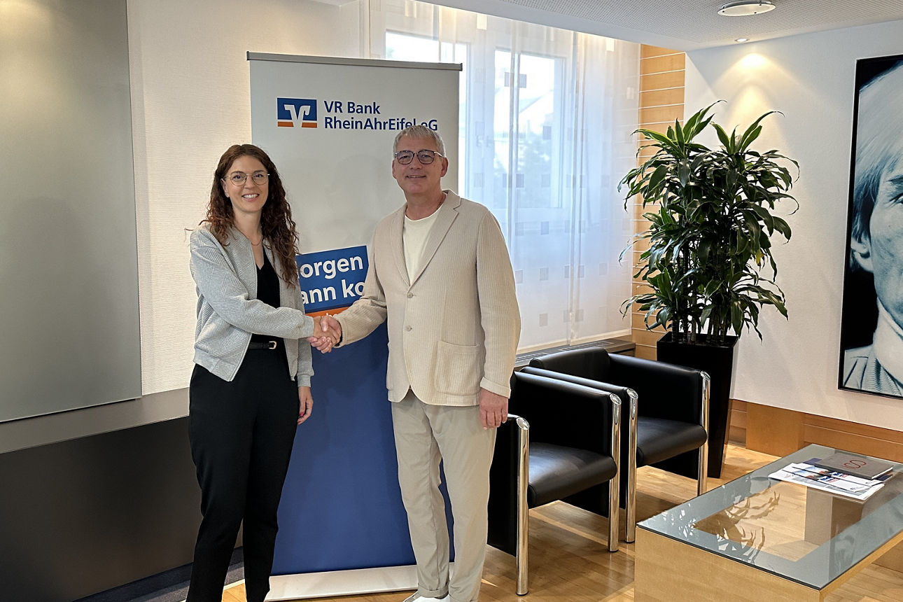 Zwei Personen in Business-Kleidung geben sich in einer Filiale der VR Bank RheinAhrEifel eG die Hand.
