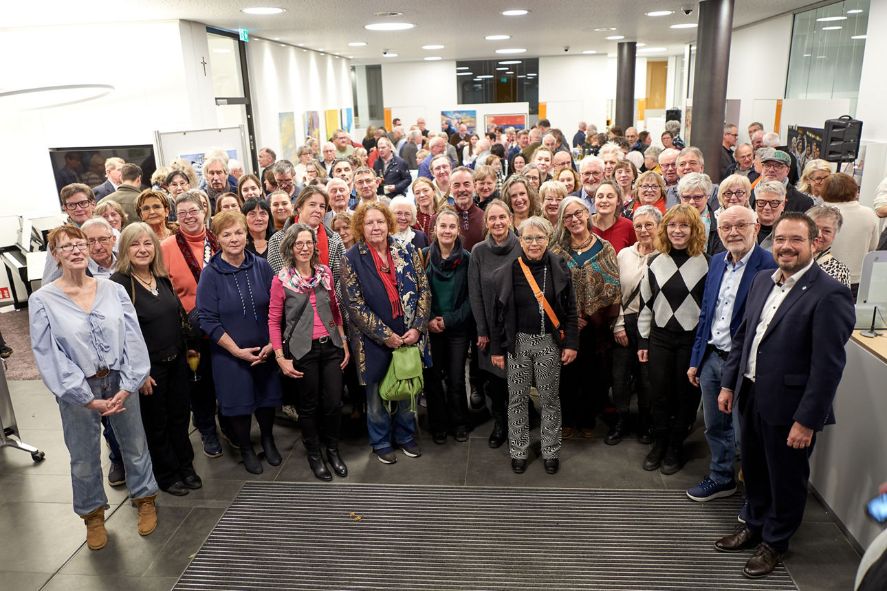 Große Besuchergruppe bei Vernissage in modernem Ausstellungsraum mit zeitgenössischer Kunst an den Wänden