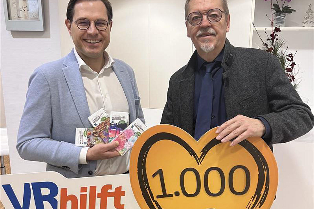 Auf dem Bild stehen der stellvertretender Vorstandsvorsitzender der VR-Bank und ein Mann der Lokalen Agenda Schweinfurt. Sie halten ein Schild in Herzform mit der  Spendensumme von 1.000 Euro in der Hand. 