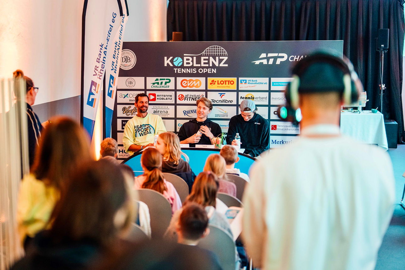 Podium mit drei Personen bei den Koblenz Tennis Open, Kinderpublikum, Banner und VR Bank RheinAhrEifel eG