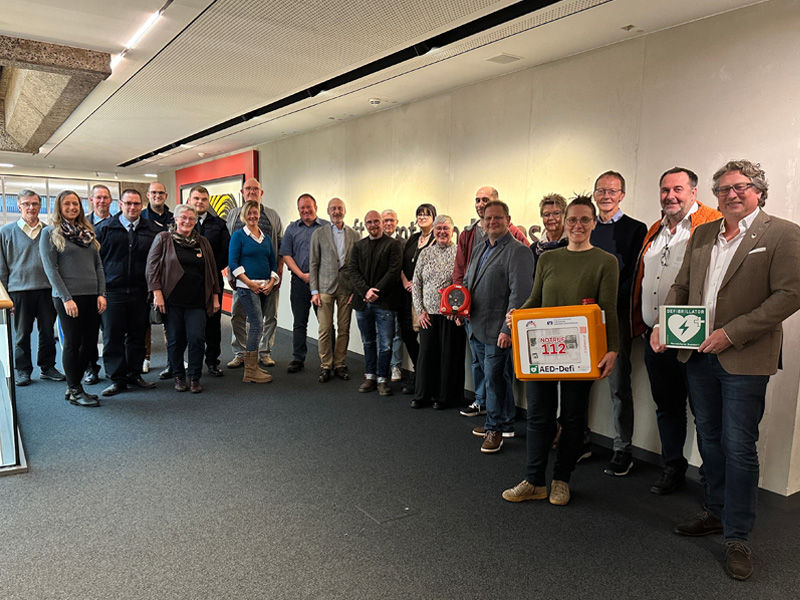 Die Vereinsvertreter halten die gewonnenen Defibrillatoren in den Händen.