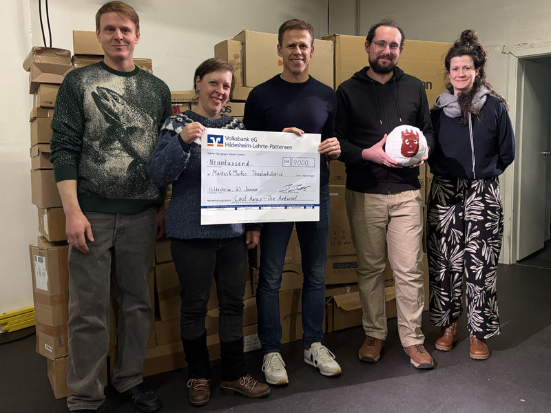 Fünf Personen halten einen Überreichungsscheck in der Hand