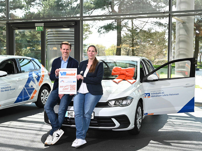 Ein Mann und eine Frau lehnen an der Motorhaube eines VW Polo