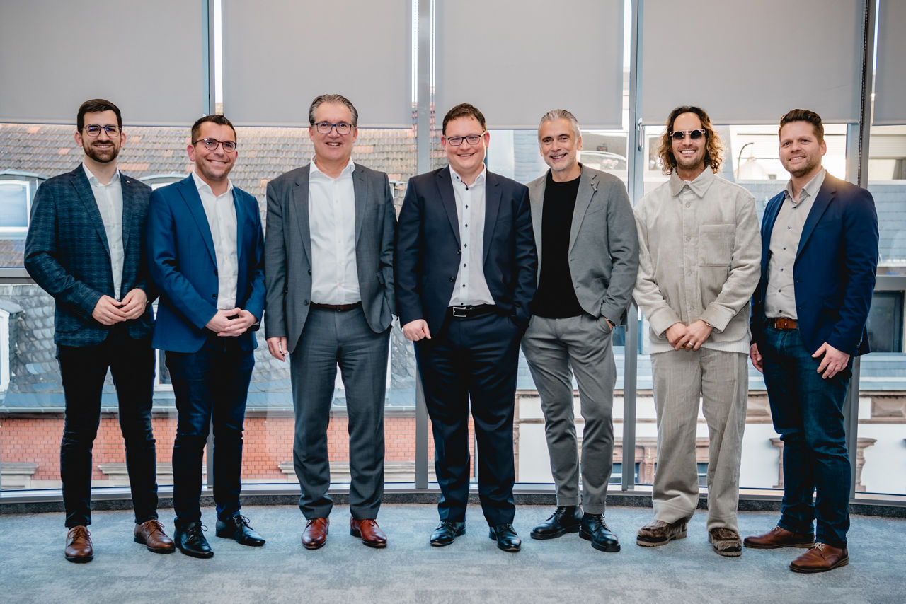 Sieben Herren im Casual Business Outfit bei der Eröffnungsfeier