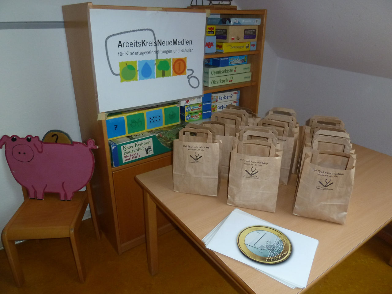 Papiertüten mit Geschenken und Spielgeld zum Ausschneiden liegen auf einem Tisch.