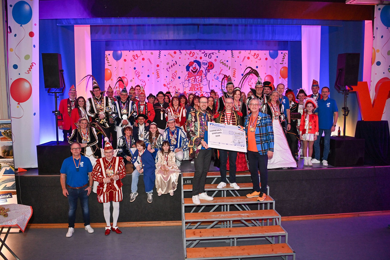 Viele kostümierte Menschen haben sich auf einer Bühne zum Gruppenfoto aufgestellt