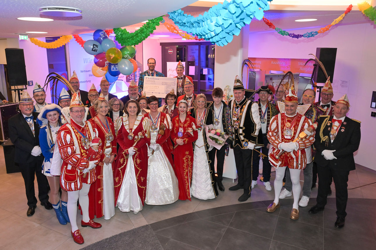 Mehrere Personen stehen in karnevalistischer Kleidung zu einem Gruppenbild zusammen.