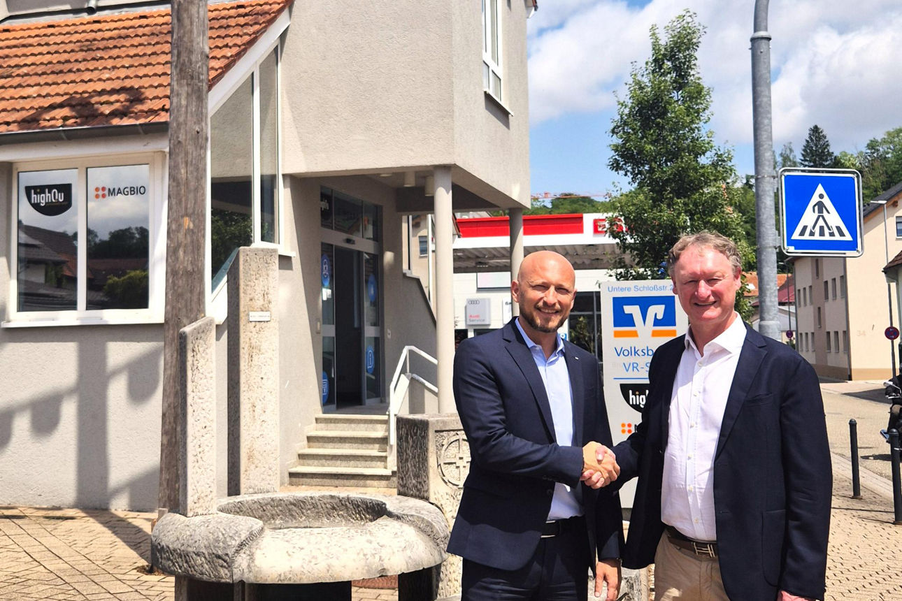 Vorstand Dimitrios Meletoudis und ein Vertreter der Sparkasse stehen vor einer Volksbank Filiale