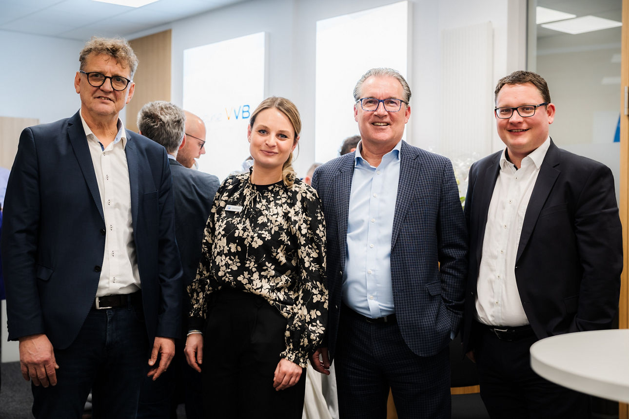 Eine Frau in Cassual Business und drei Herren im Anzug