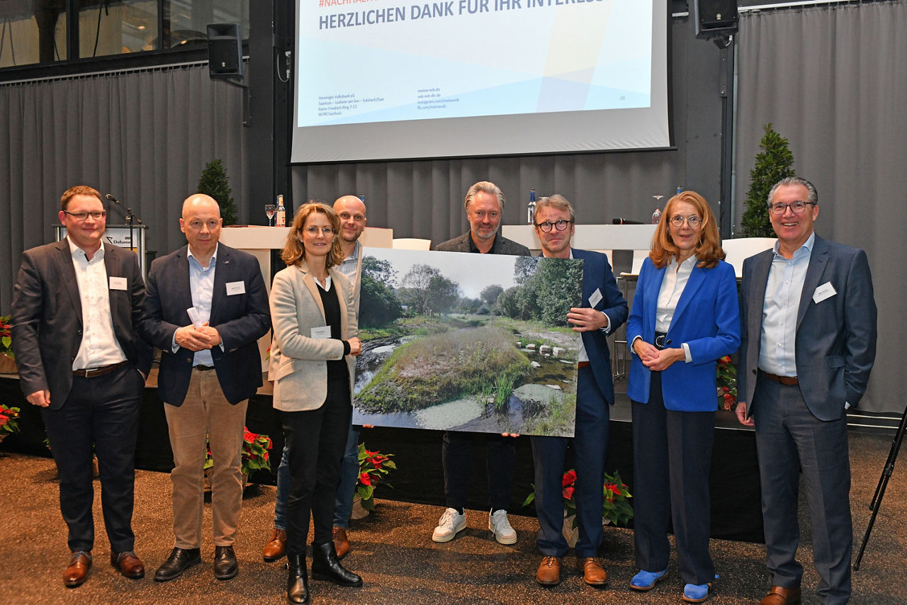 Männer und Frauen halten eine Landschaftskarte hoch