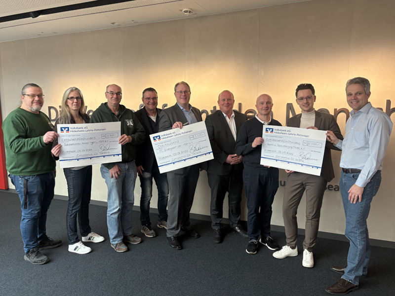 Die Vereinsvertreter halten die Überreichungsschecks in der Hand.