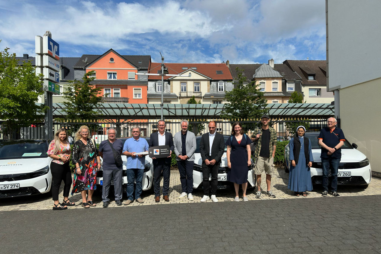 Menschen bei der Schlüsselübergabe der Spendenfahrzeuge