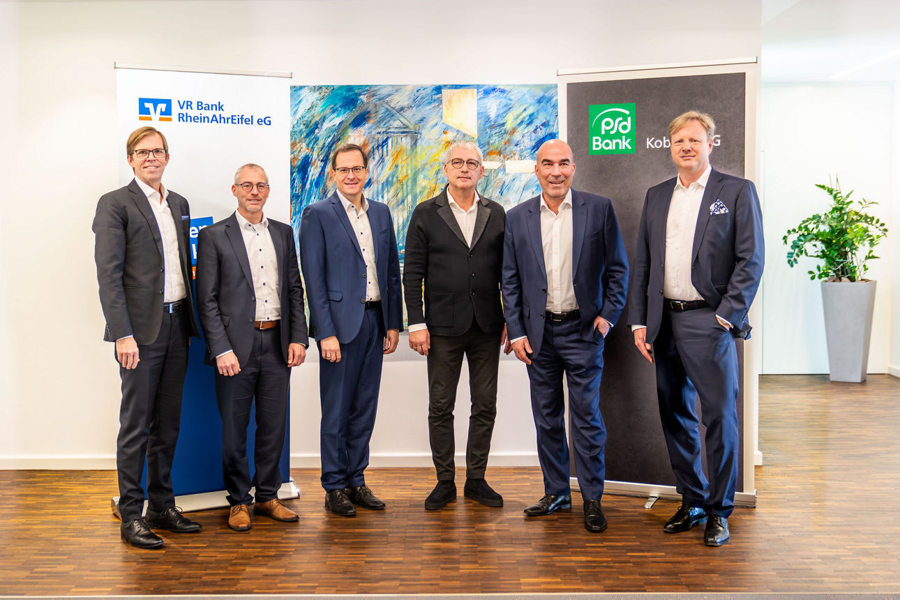 Vertreter der VR Bank RheinAhrEifel eG und Partner reichen sich vor Banner „Von Hier Vulkaneifel“ die Hände.