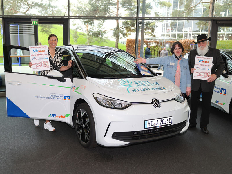 Eine Person steht links und zwei Personen stehen rechts vom eVR mobil