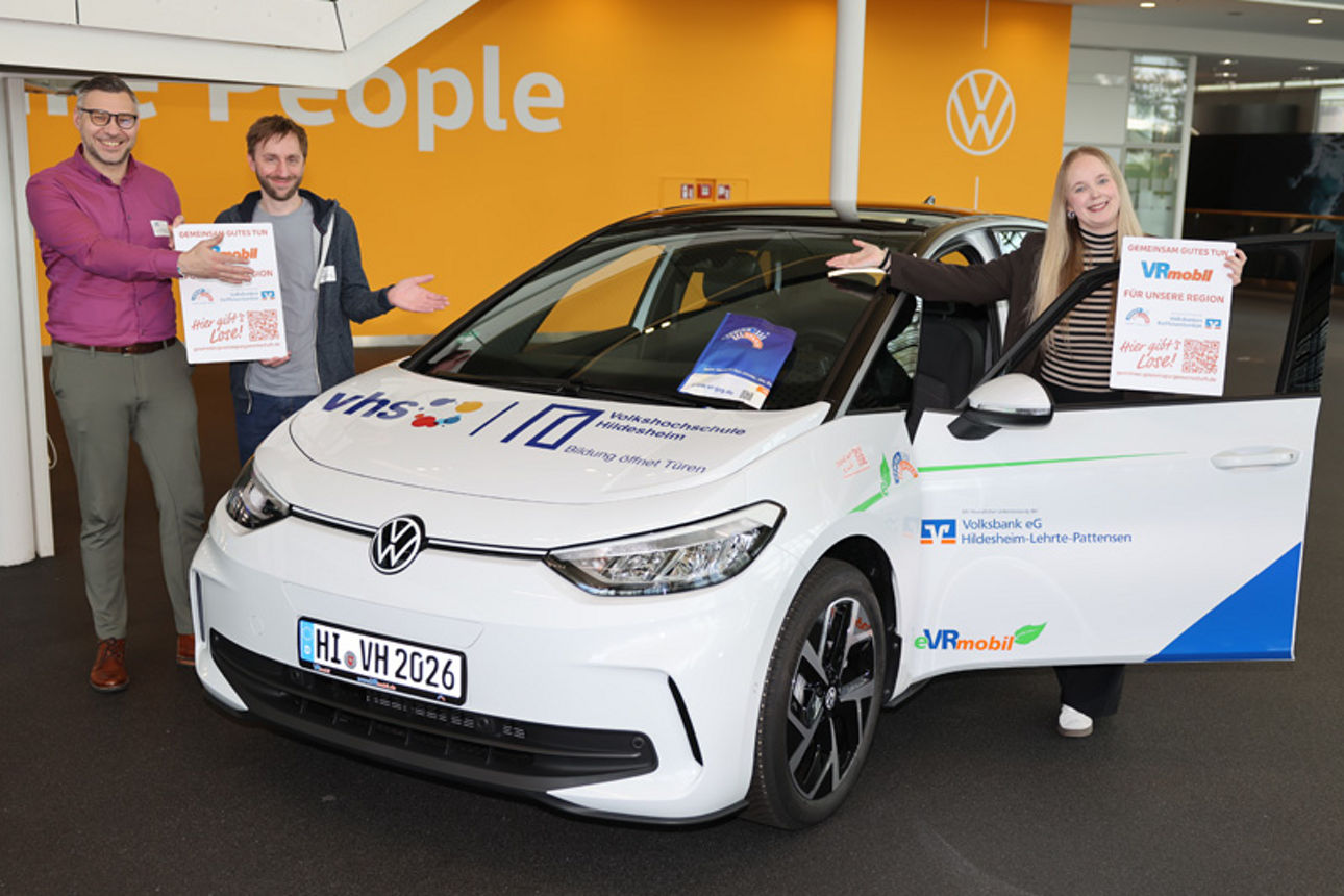 Zwei Personen stehen links und eine Person steht rechts neben dem eVRmobil