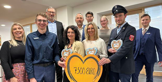 Eine bunte Gruppe von Menschen, die freudig ein Schild halten