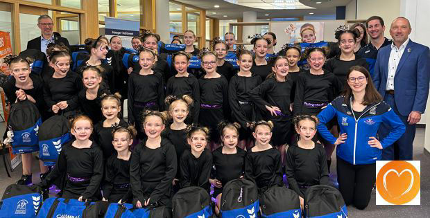 Eine Gruppe junger Mädchen in blauen Uniformen lächelt
