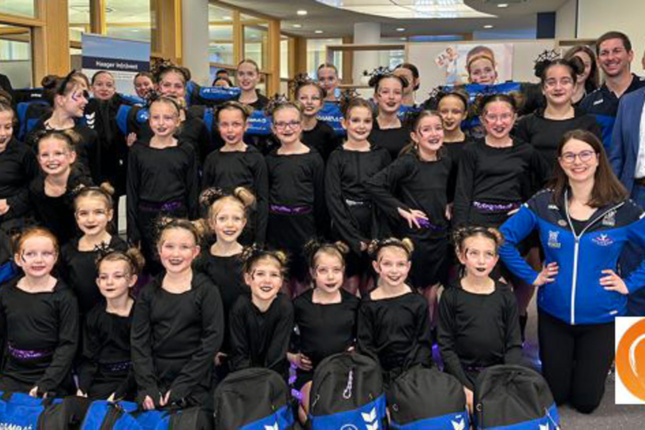 Eine Gruppe junger Mädchen in blauen Uniformen lächelt