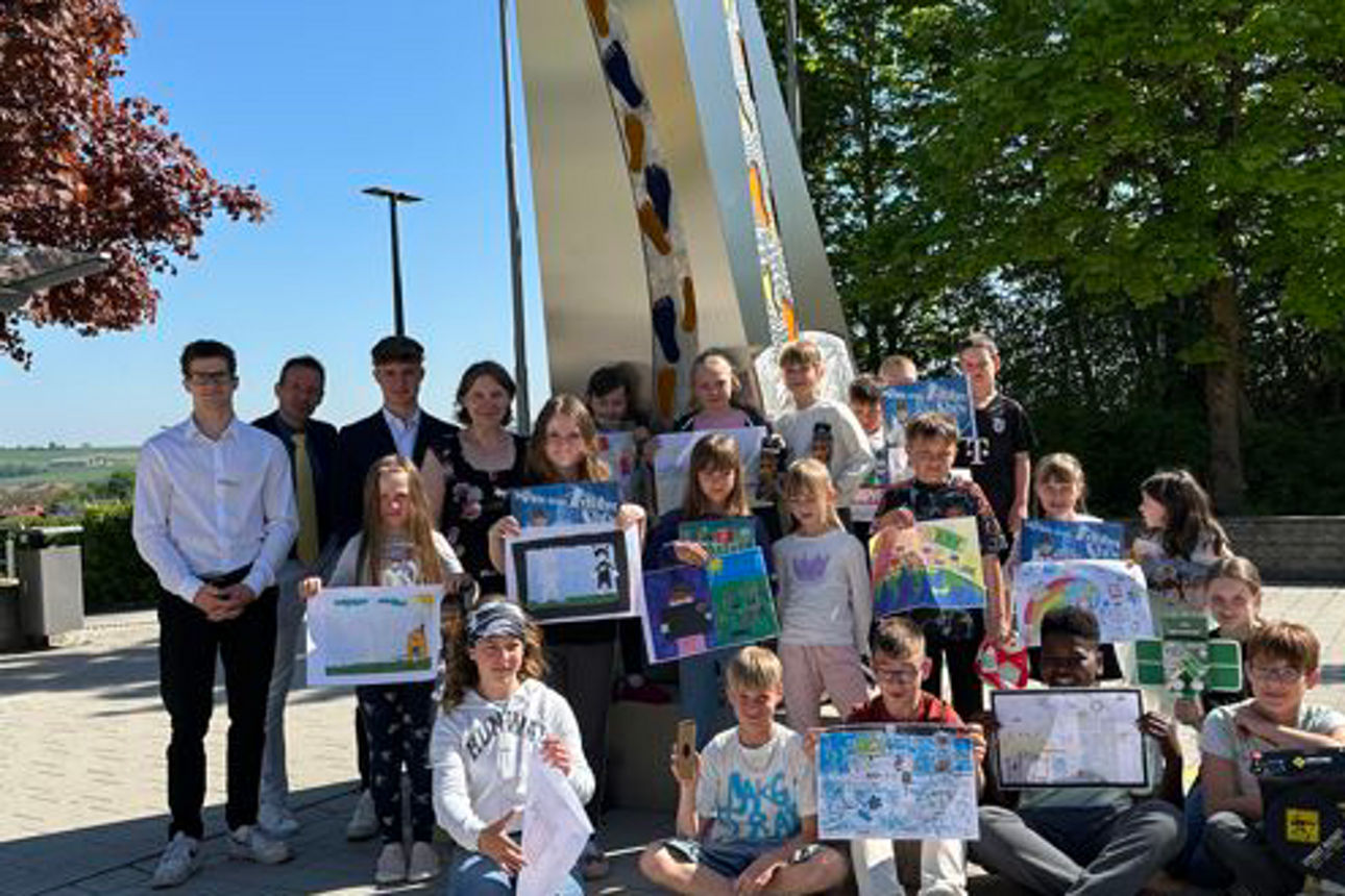 Eine Gruppe von Kindern zeigt gemalte Bilder in die Kamera