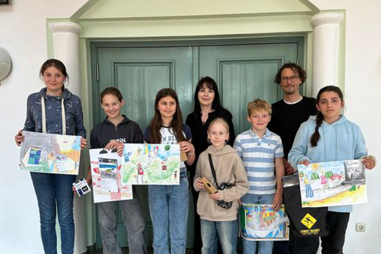 Eine Gruppe von Kindern zeigt gemalte Bilder in die Kamera