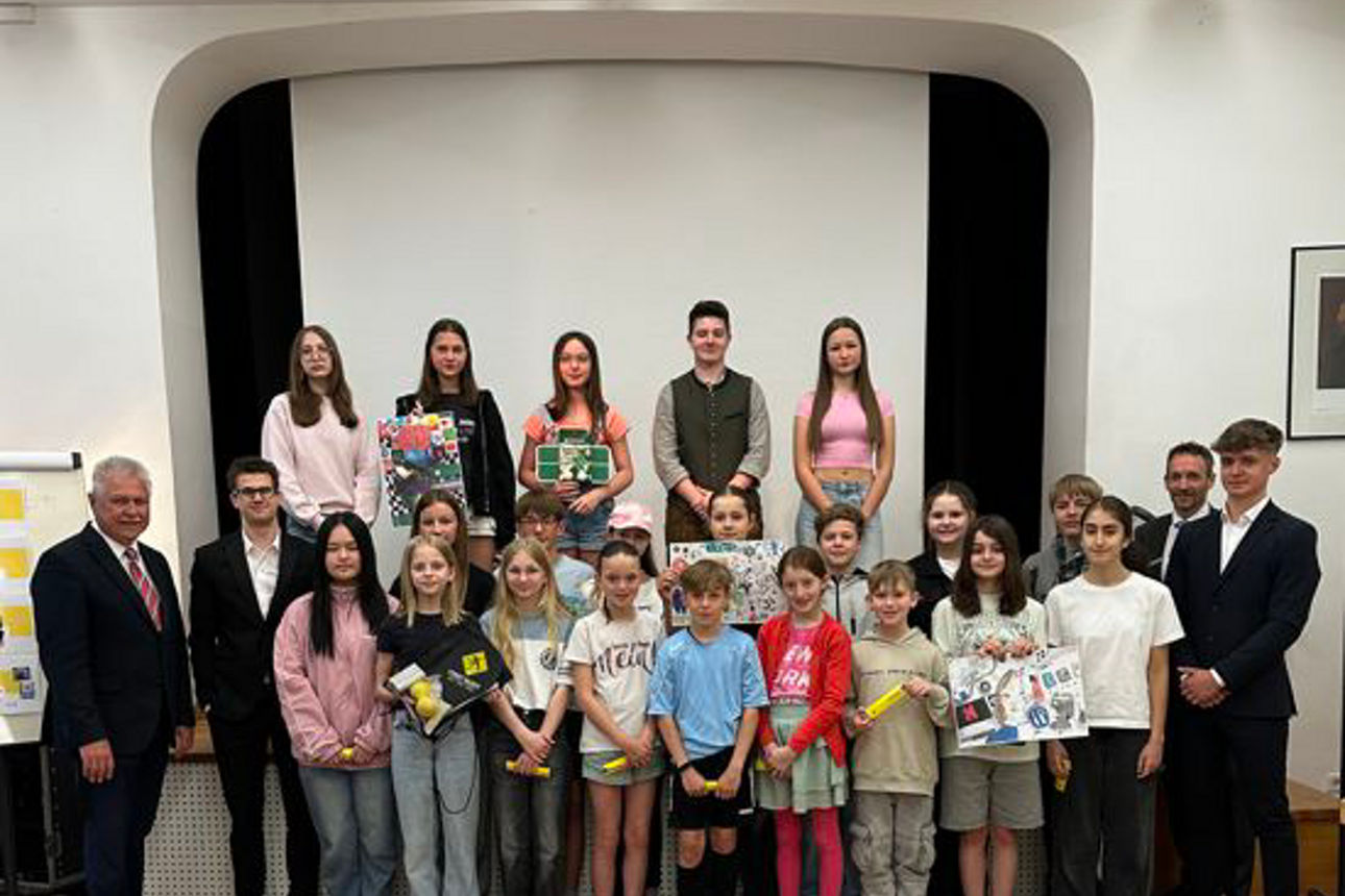 Eine Gruppe von Kindern zeigt gemalte Bilder in die Kamera