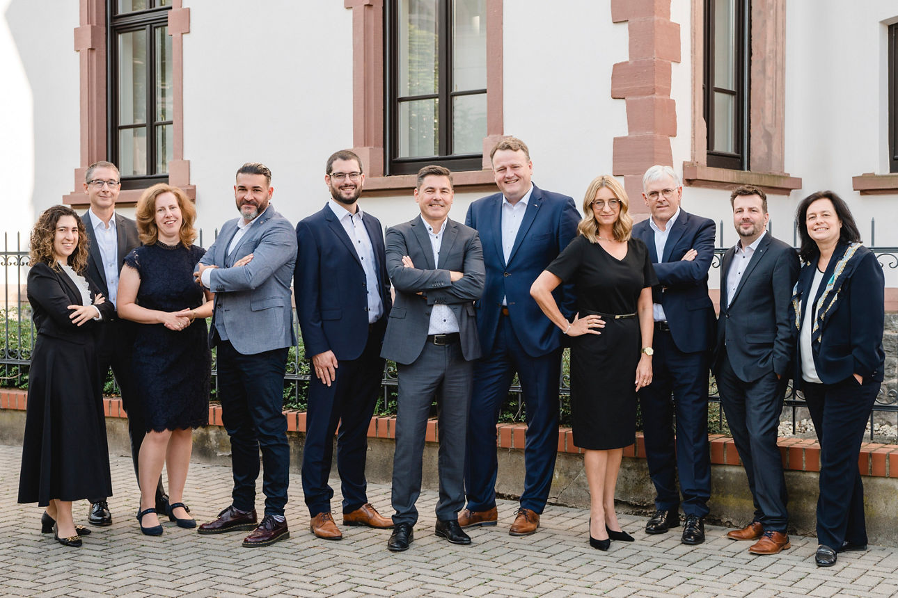 Elf Mitarbeitende der PrivatBank stehen vor einem Gebäude