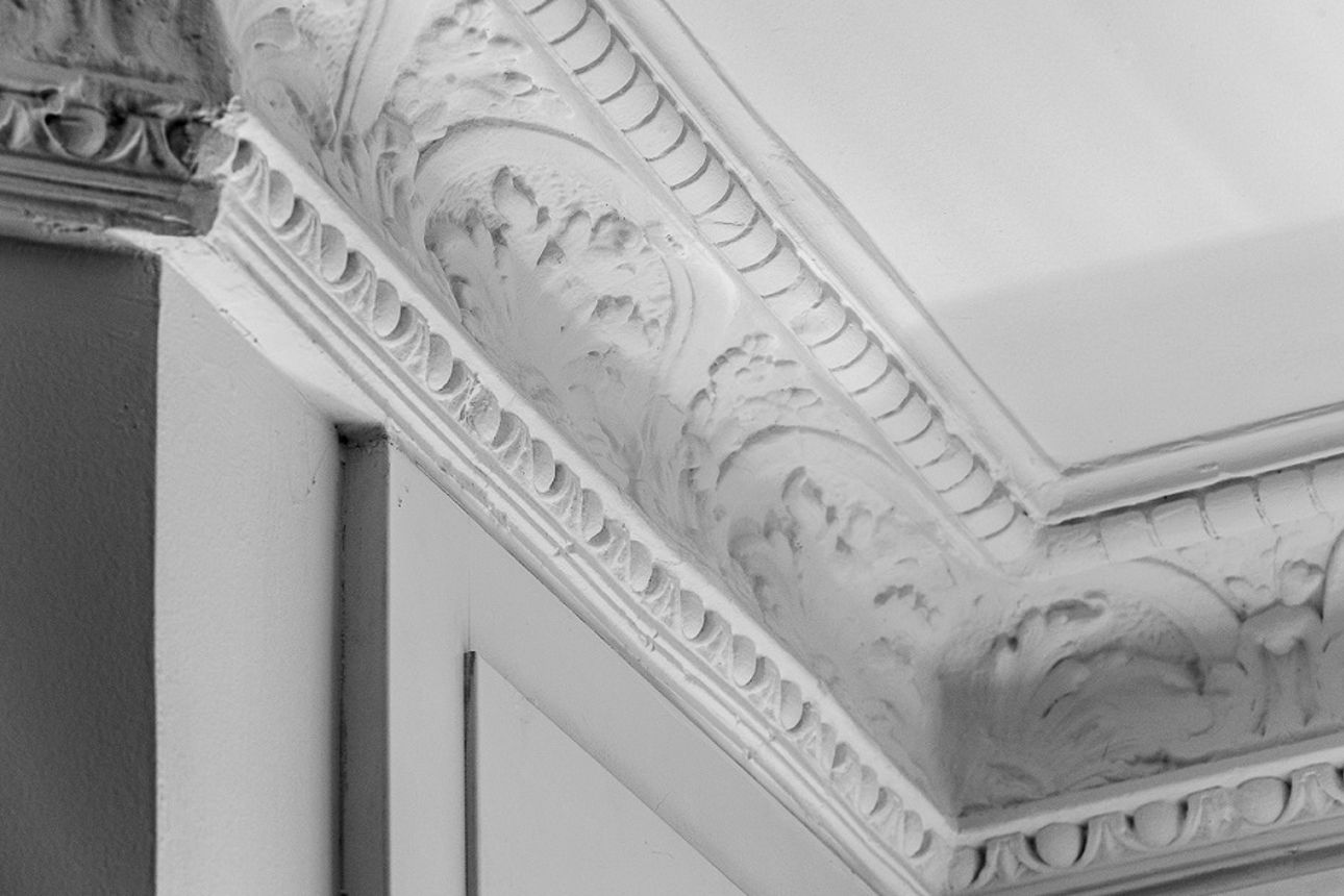 Eine weiße Wand mit Stuckverzierung