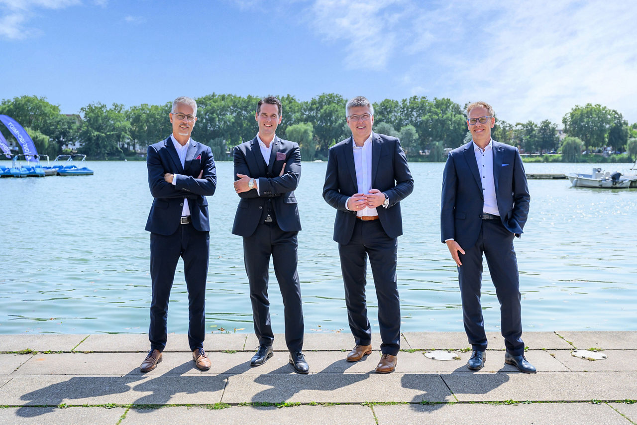 Die vier Leiter des Private Bankings stehen vor dem Aasee in Münster.