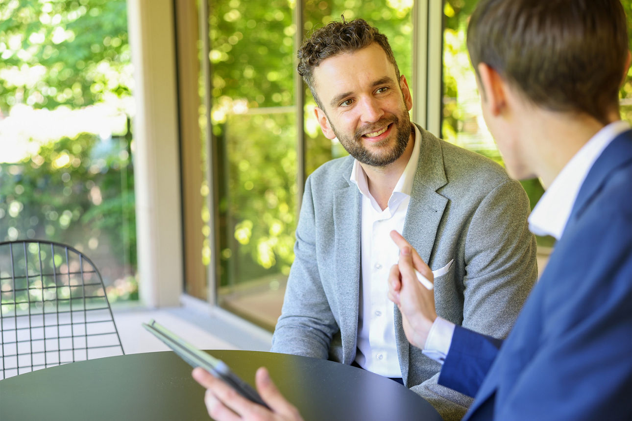 Zwei Männer unterhalten sich an einem Tisch