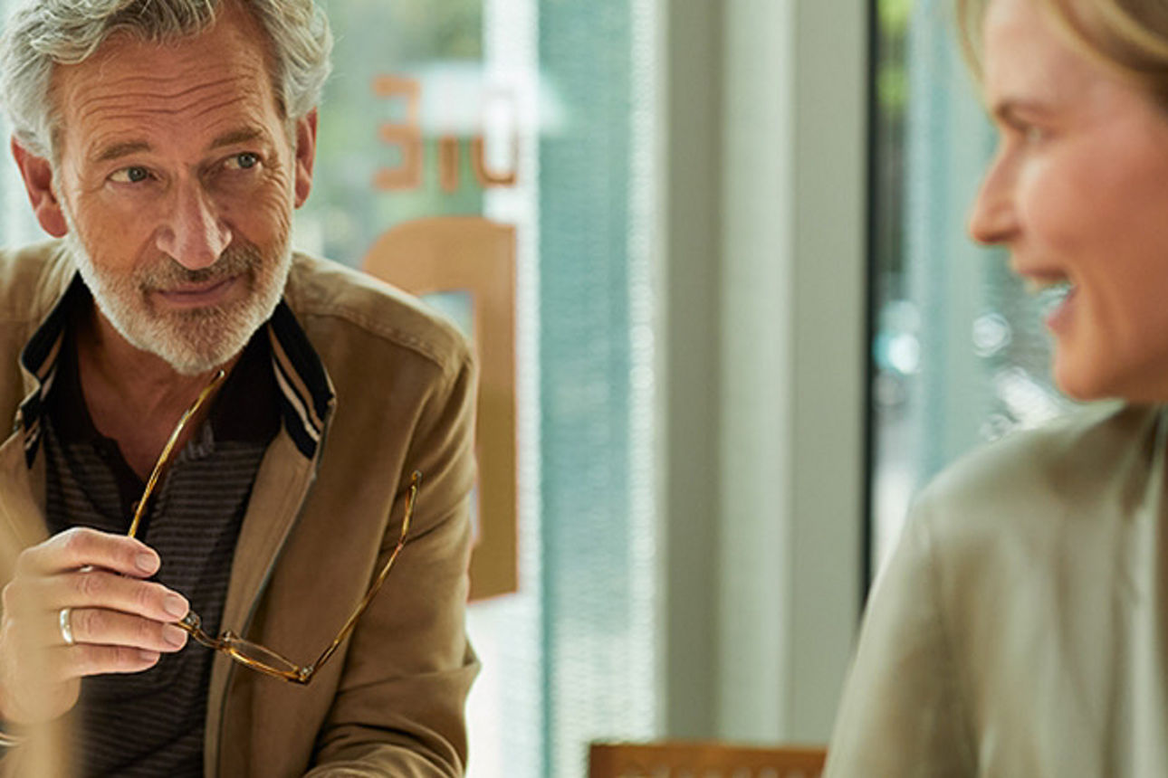 Zwei Männer und zwei Frauen stehen lächelnd nebeneinander