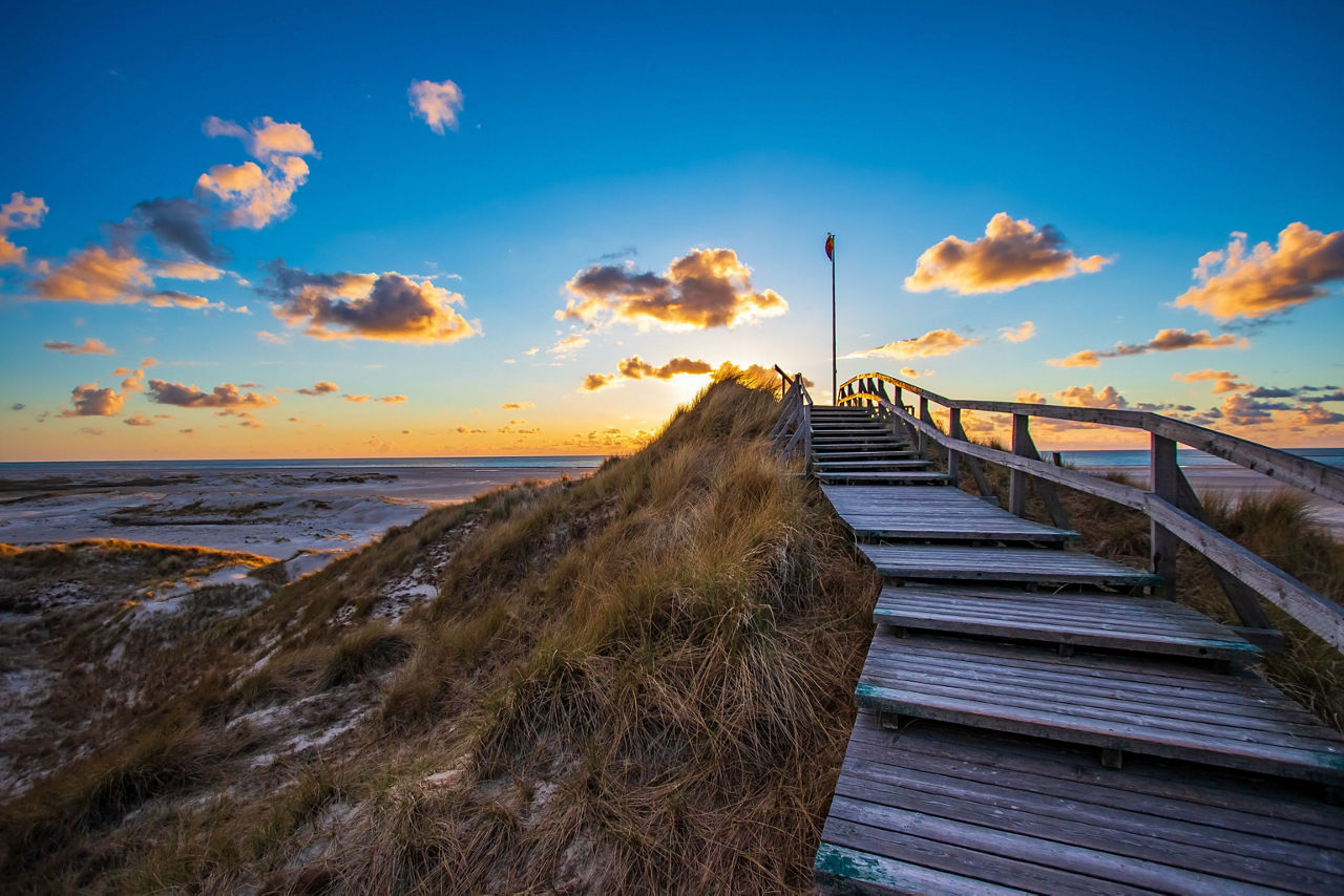 Holzbrücke führt an einen Strand