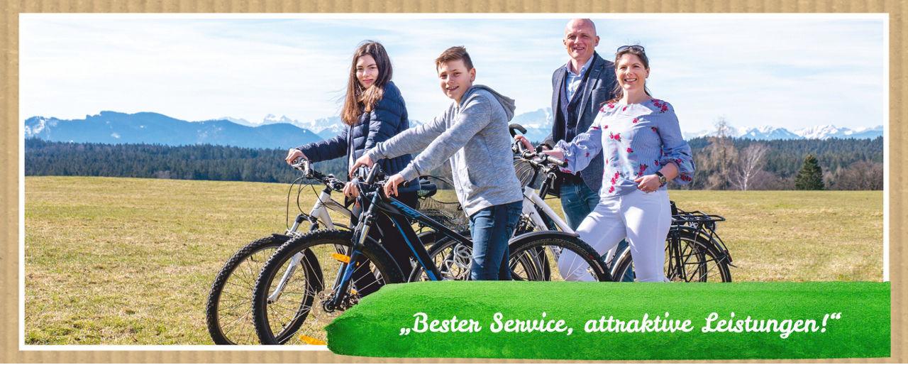 Familie mit Fahrrädern steht auf einer Wiese