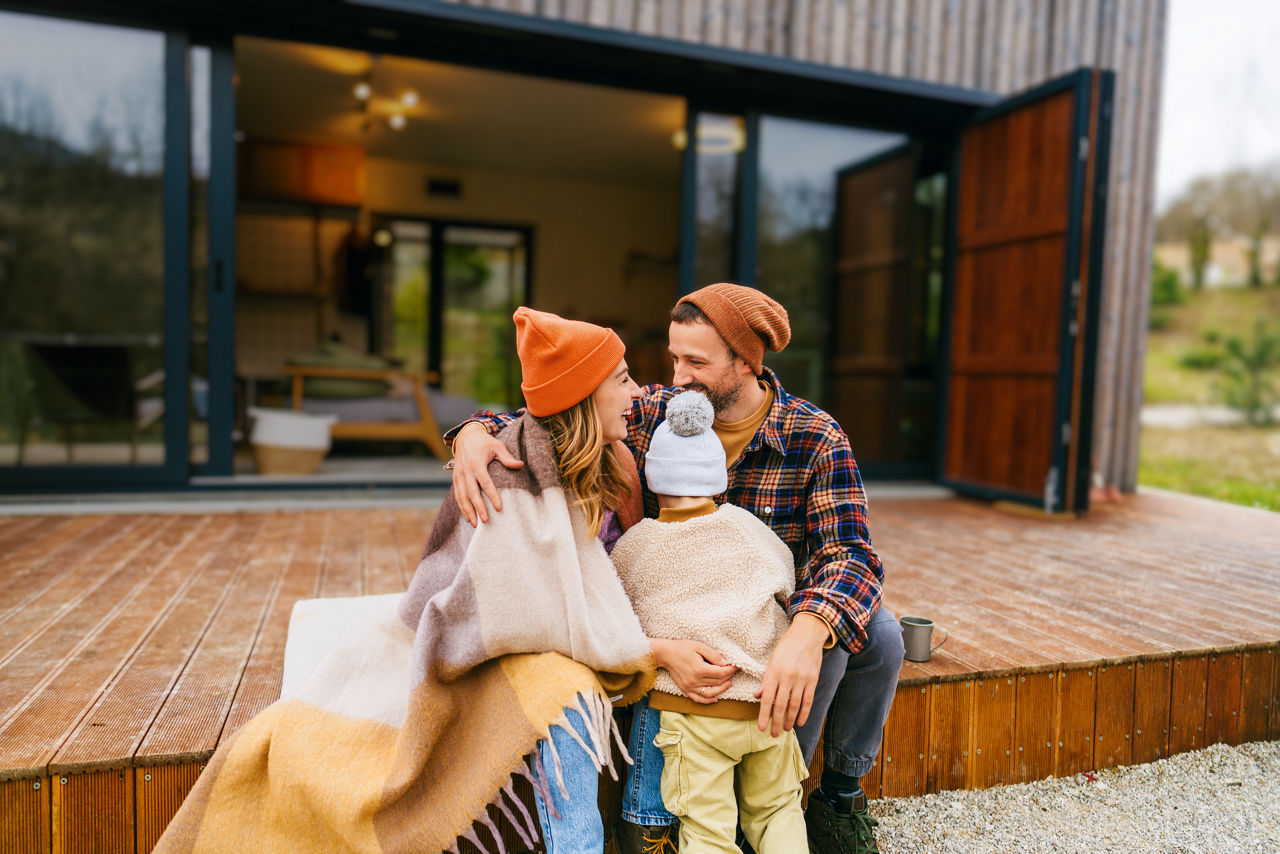 Mutter und Vater halten ihr Kind auf einer Veranda