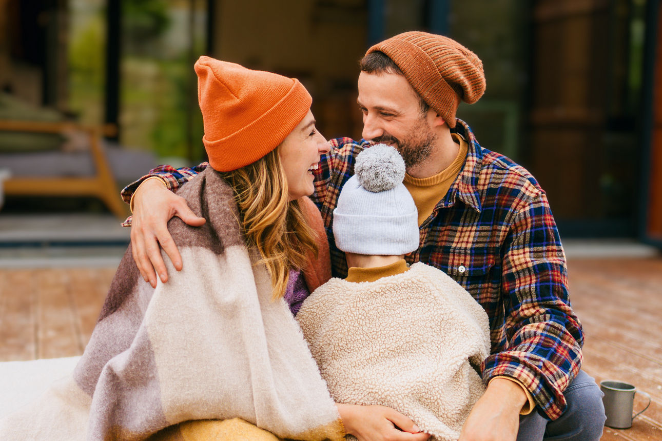 Mutter und Vater halten ihr Kind auf einer Veranda