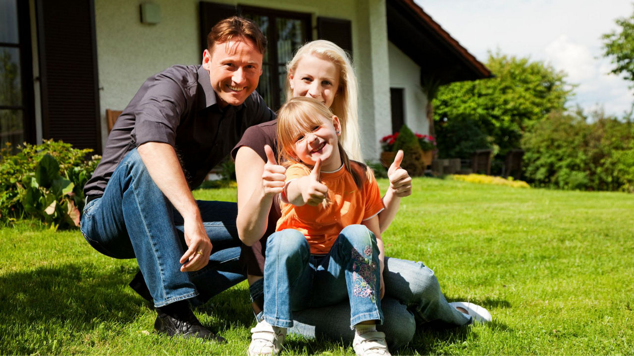 Eine Familie auf dem Rasen vor Ihrem Haus