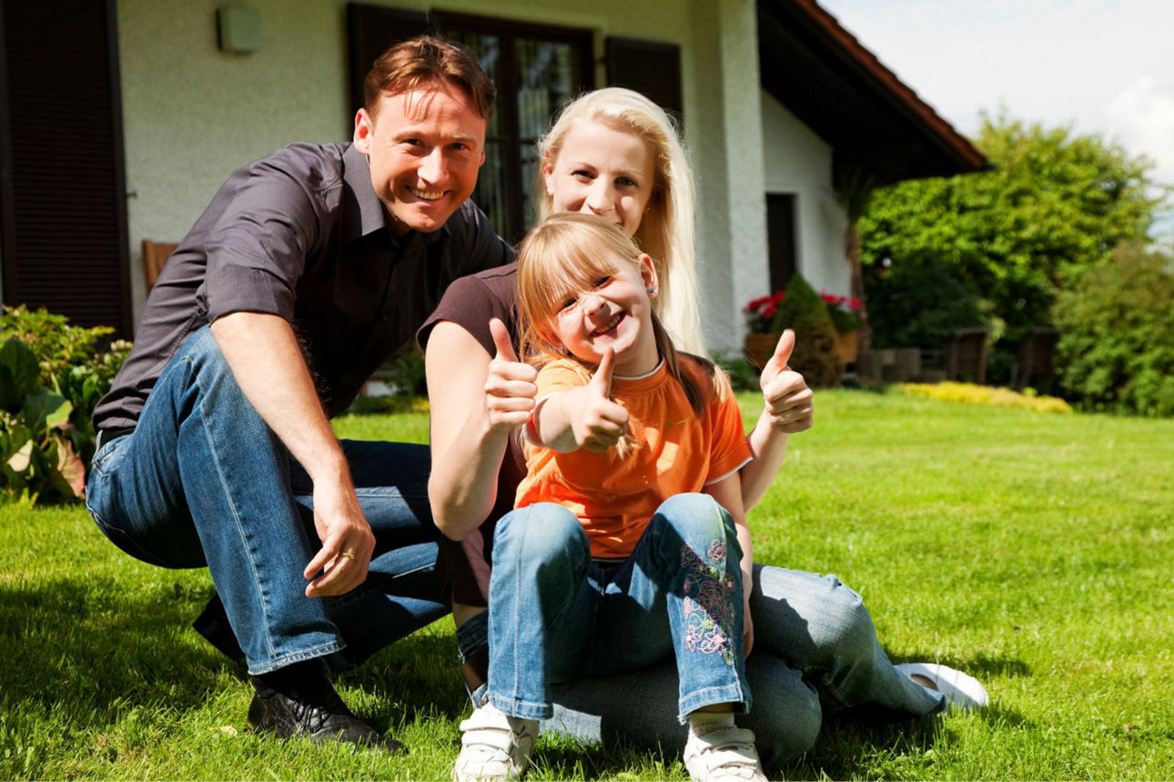 Eine Familie auf dem Rasen vor Ihrem Haus