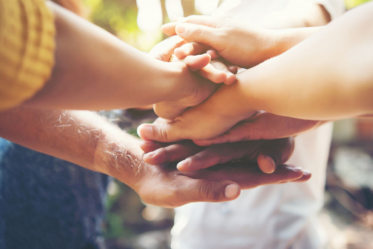 Drei Erwachsene sitzen mit Laptop am Küchentisch
