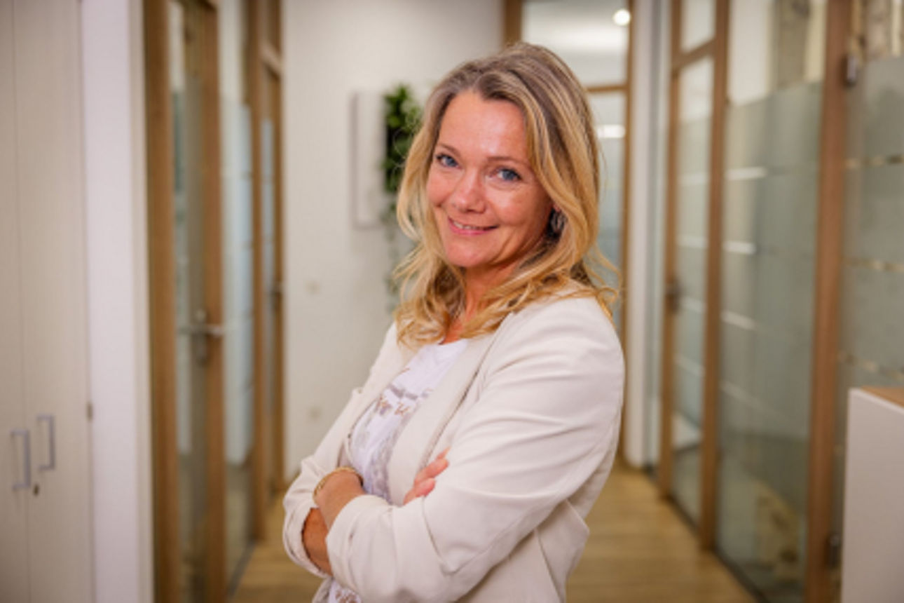 Eine blonde Frau lächelt in die Kamera.